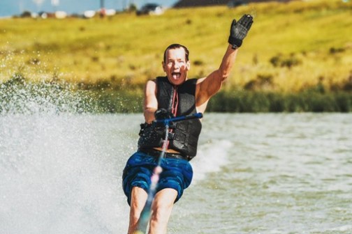 man waving while skiing