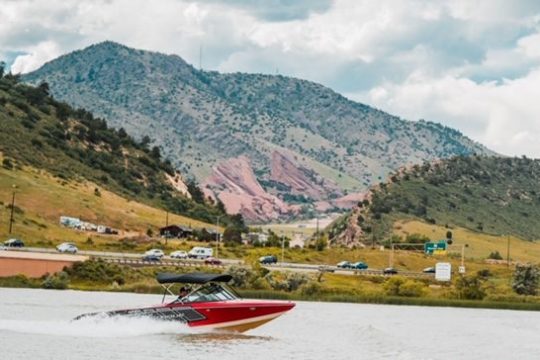 a small boat in a body of water with a mountain in the background